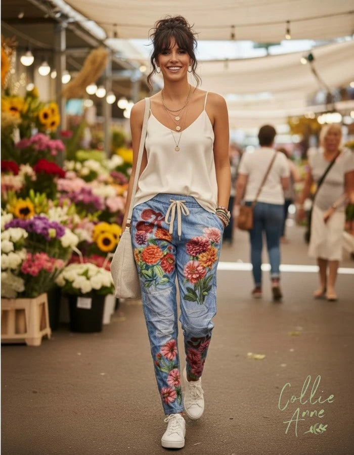 Blue denim-look stretch pants with flower print in meadow orange and pinks